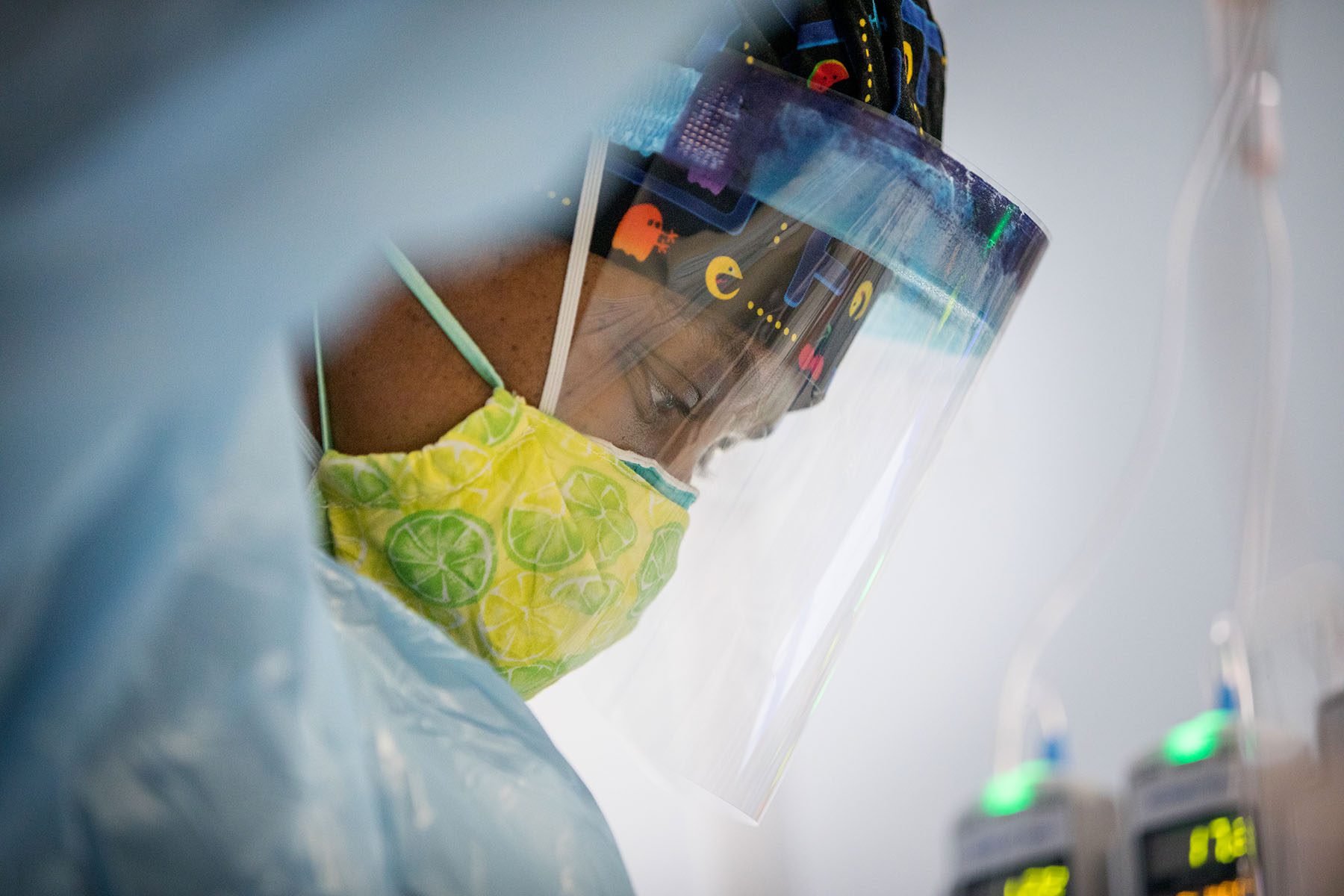 A nurse adjusts an electrode on a COVID-19 patient on a ventilator.