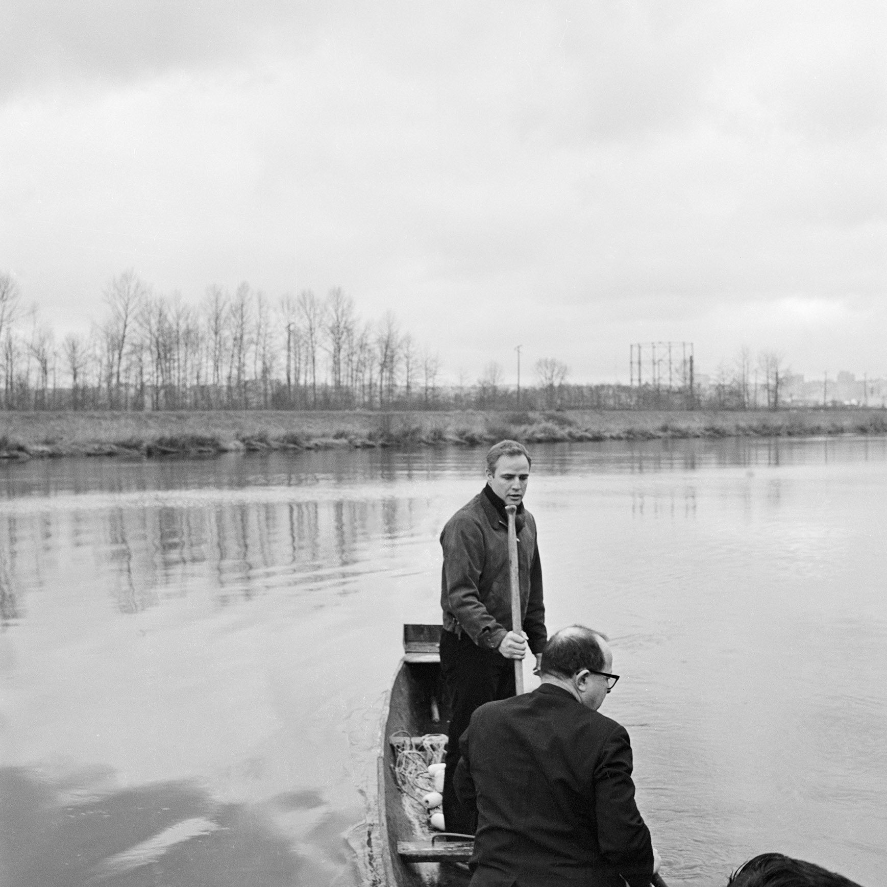 Marlon Brando pushes away from shore in a barge along the Puyallup River.
