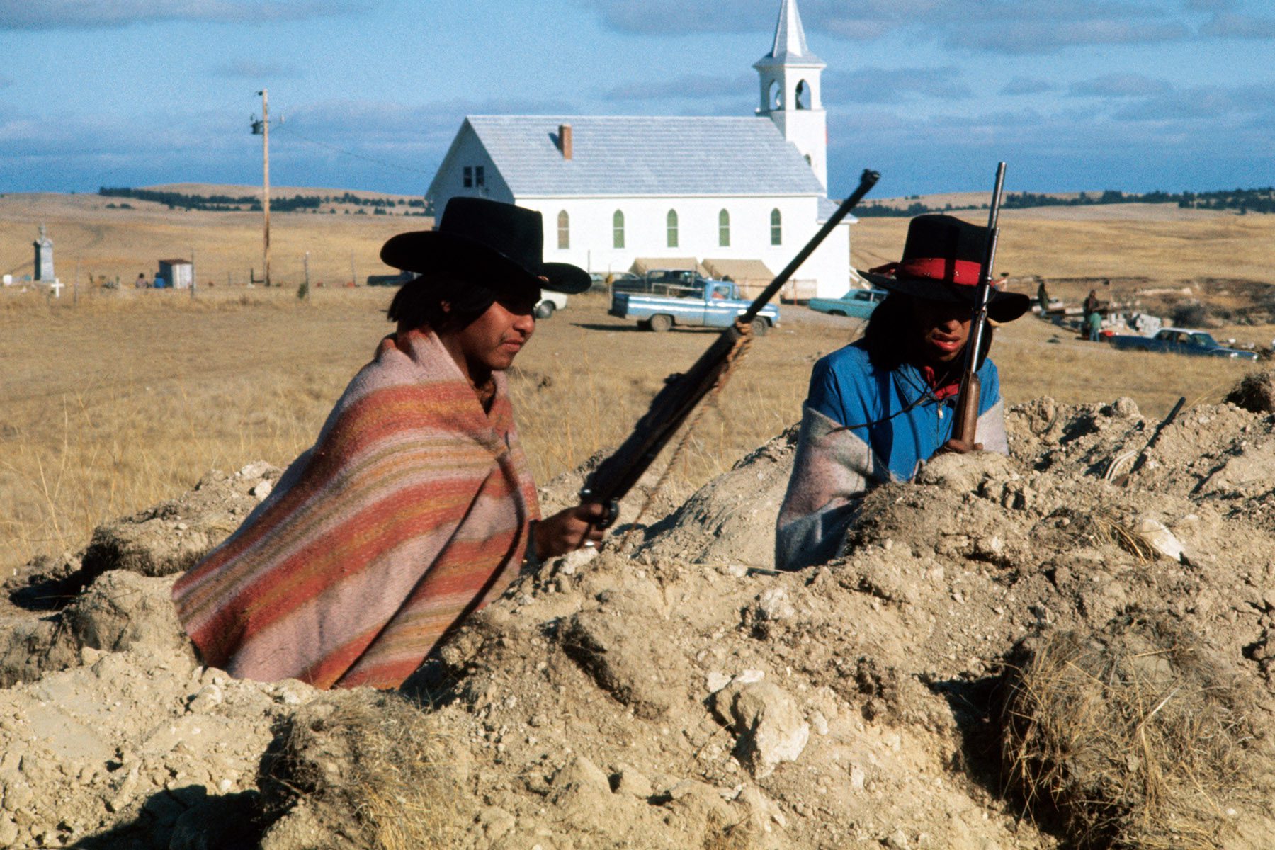 Two Oglala Sioux tribesmen man guard a post from a trench.