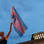 A protesters demonstrates against anti-trans legislation in front of the Ohio Statehouse.