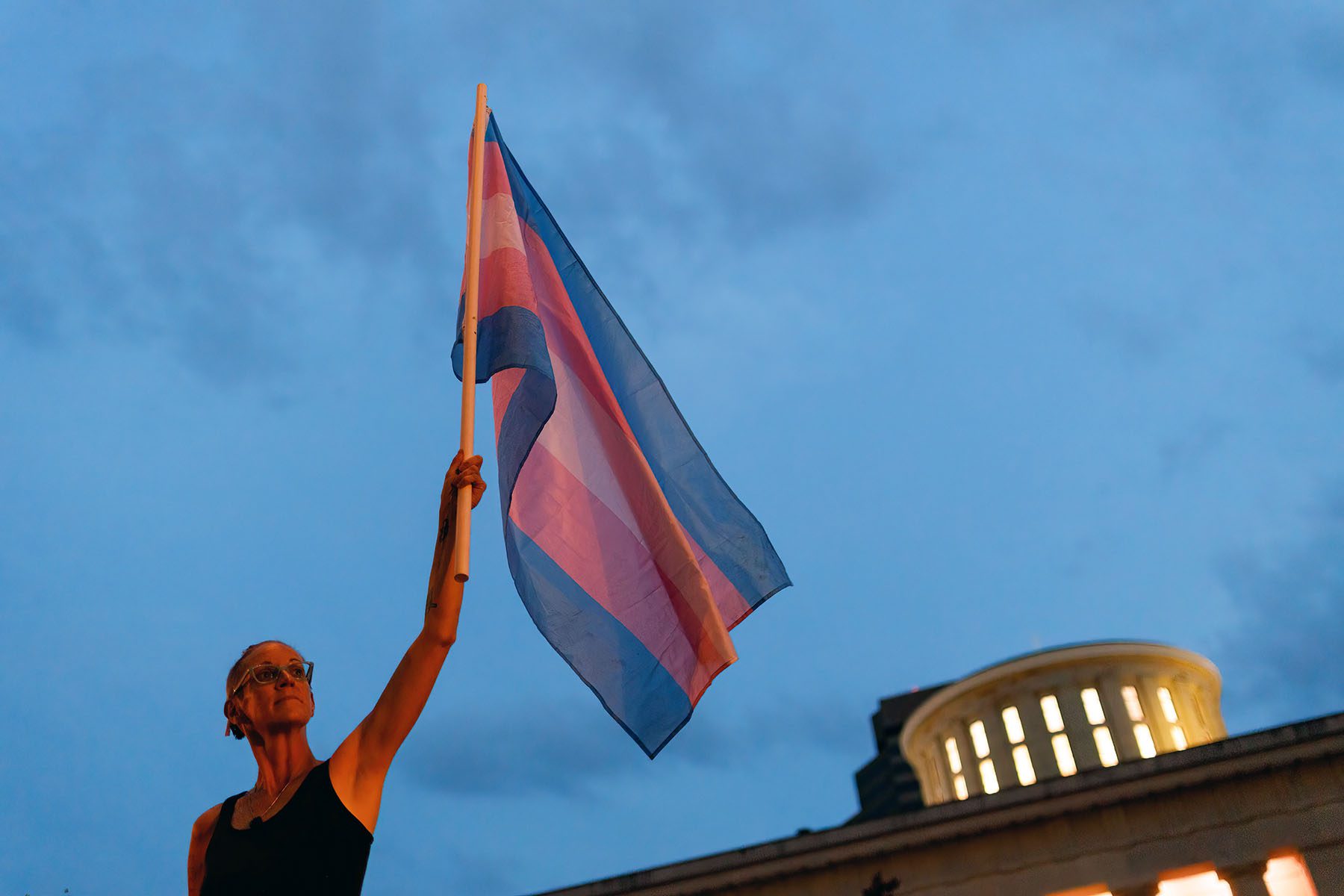 A protesters demonstrates against anti-trans legislation in front of the Ohio Statehouse.