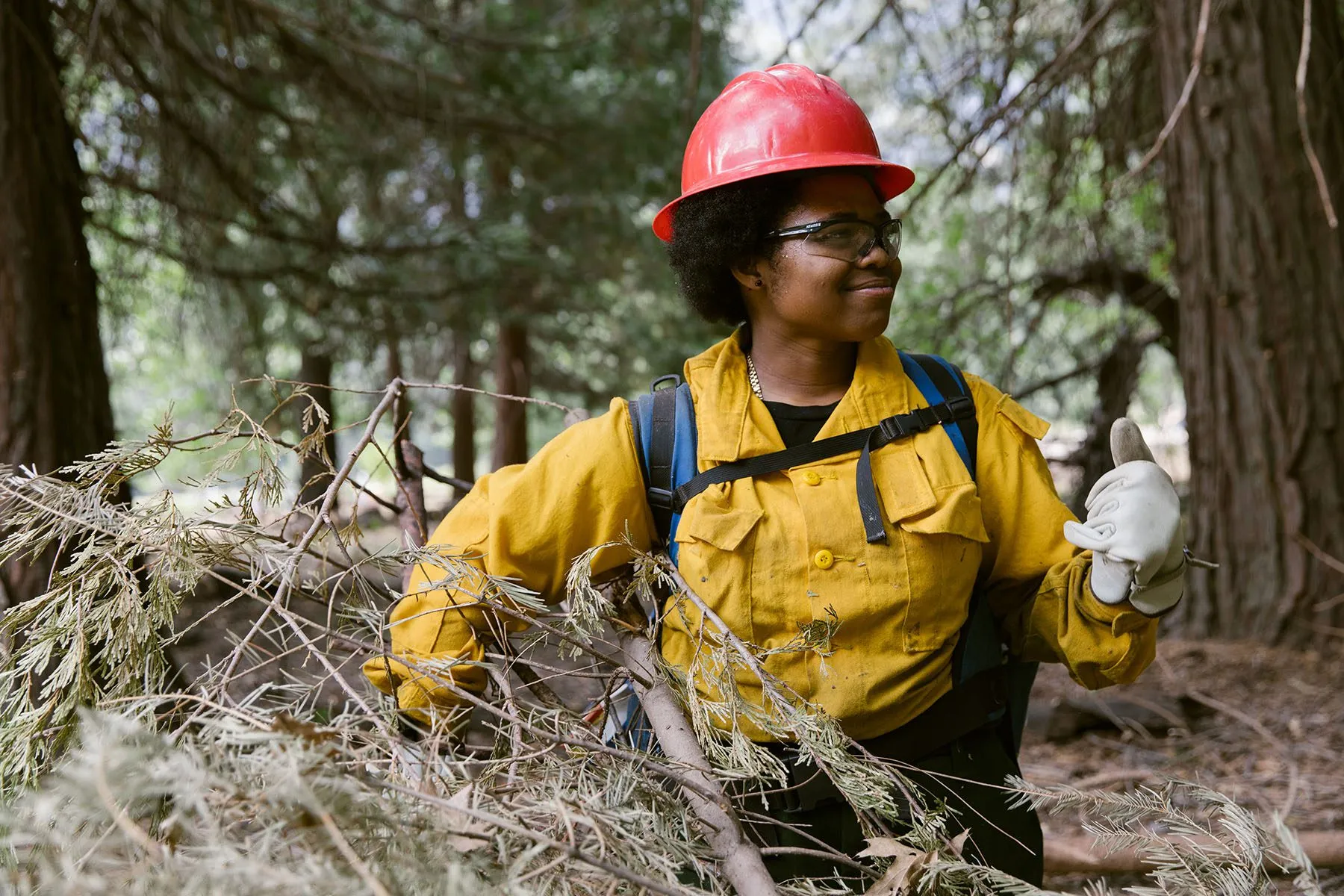 Tricia Andrews, 25, poses for a portrait and smiles while holding wood.