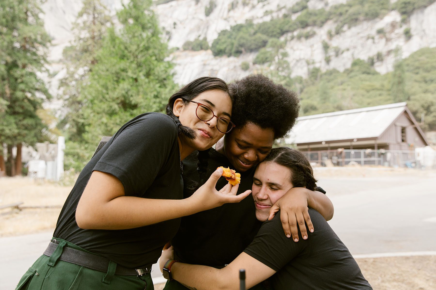 Marlene Chavez, Tricia Andrews and Guadalupe Ruiz hug and smile as they have lunch.