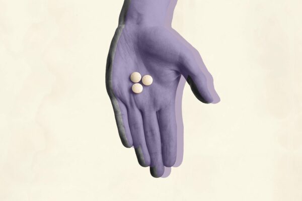 Photo illustration showing a hand holding Mifepristone pills.
