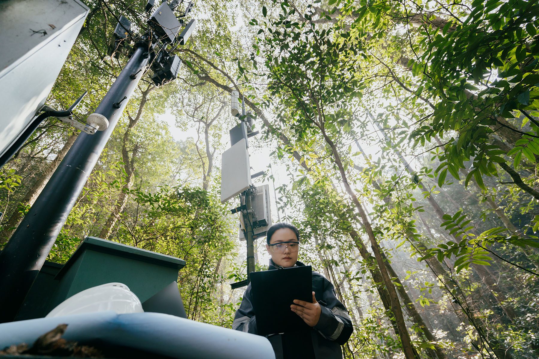Asian female engineer debugging a 5G signal base station.
