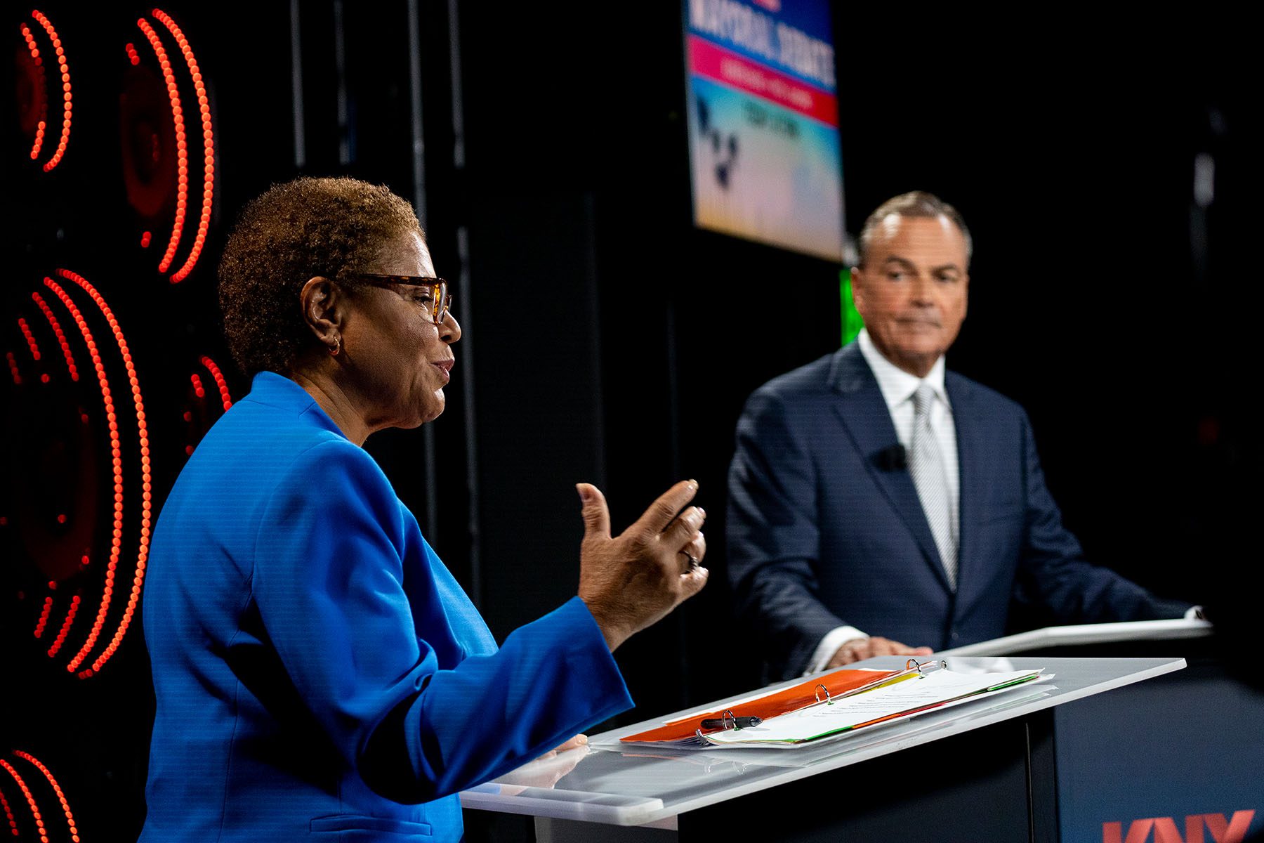 Congresswoman Karen Bass speaks as developer Rick Caruso listens during the second mayoral debate.