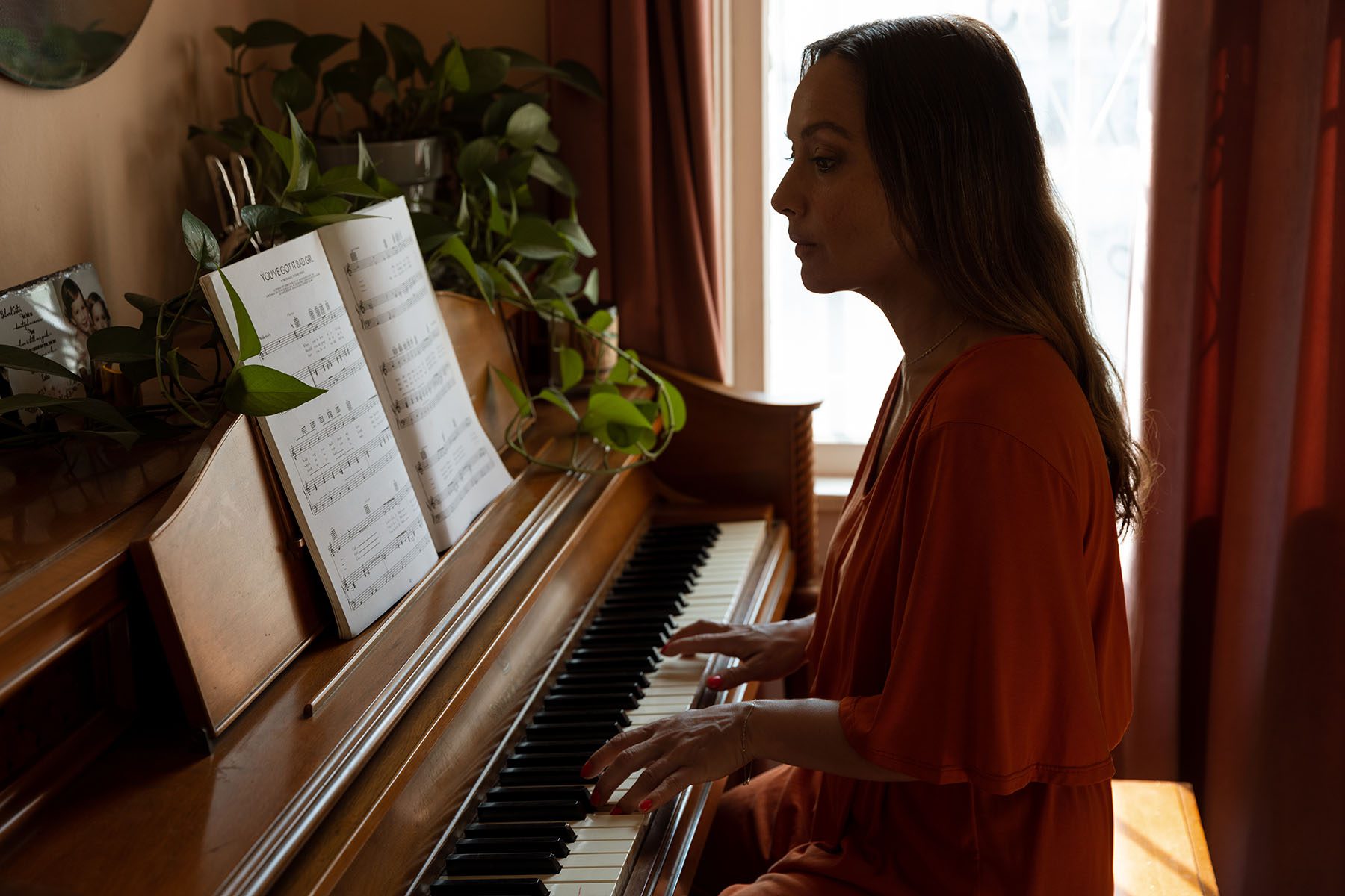 Larissa Gomes plays the piano at her home.