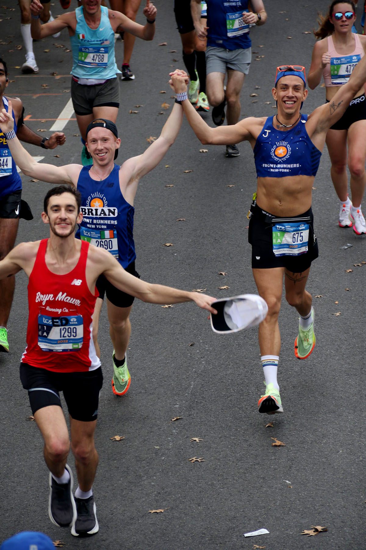 J Solle hold their teammate's hand while cheering at the NY marathon.