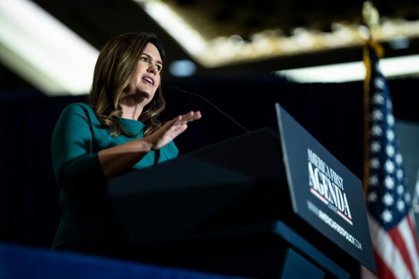 Sarah Huckabee Sanders speaks at a podium during the America First Agenda Summit.