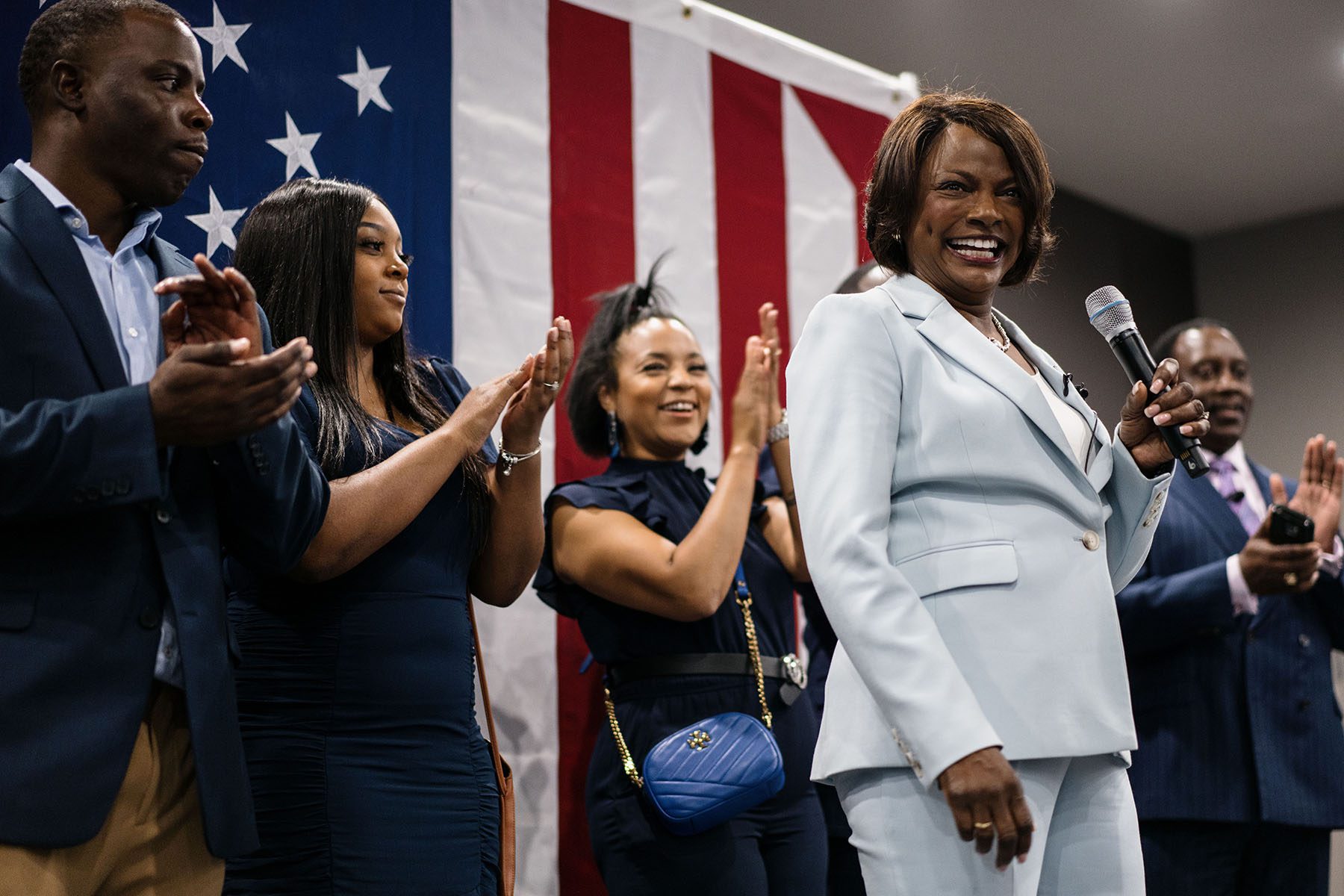 Val Demings speaks at an election watch party event. Behind her, supporters clap and cheer.