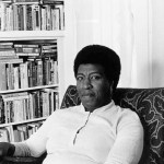 Octavia Butler poses for a portrait near her bookcase.