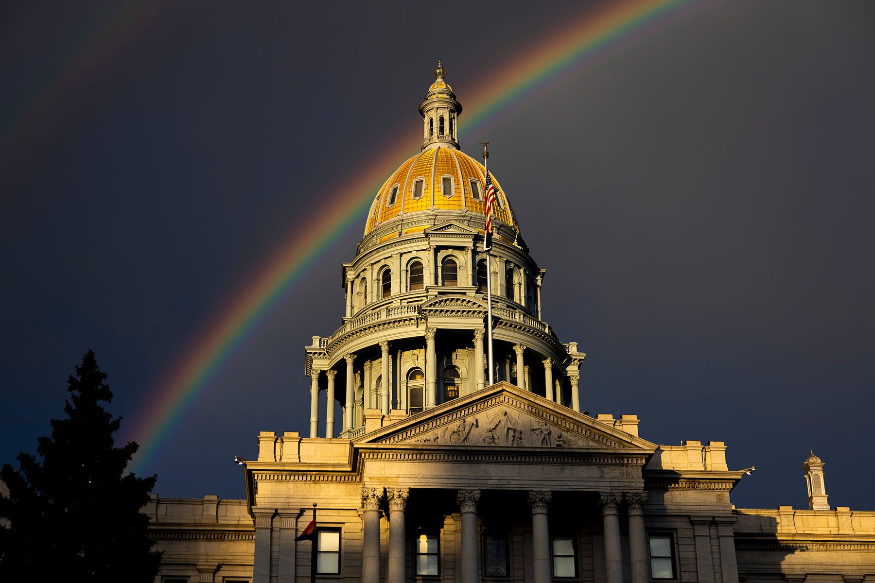 A rainbow forms above the Colorado State Capitol.