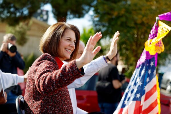 Catherine Cortez Masto waves to people as she sits on a trailer in a horse parade for Nevada Democrats.