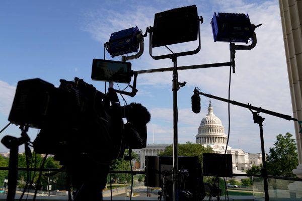 A camera and lights are set up near the U.S. Capitol.