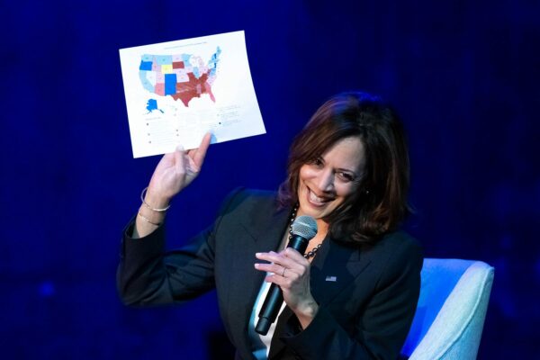 Harris holds up a map of the United States showing different states' abortion laws while speaking during a conversation about reproductive rights.