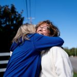 Two women volunteers hug each other as they canvass around Lexington, Kentucky.