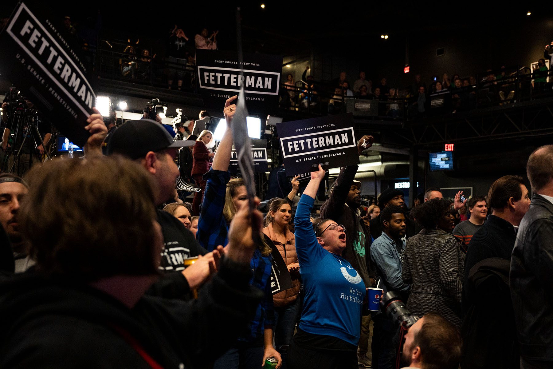 Supporters cheer and hold signs at the election night headquarters of John Fetterman.