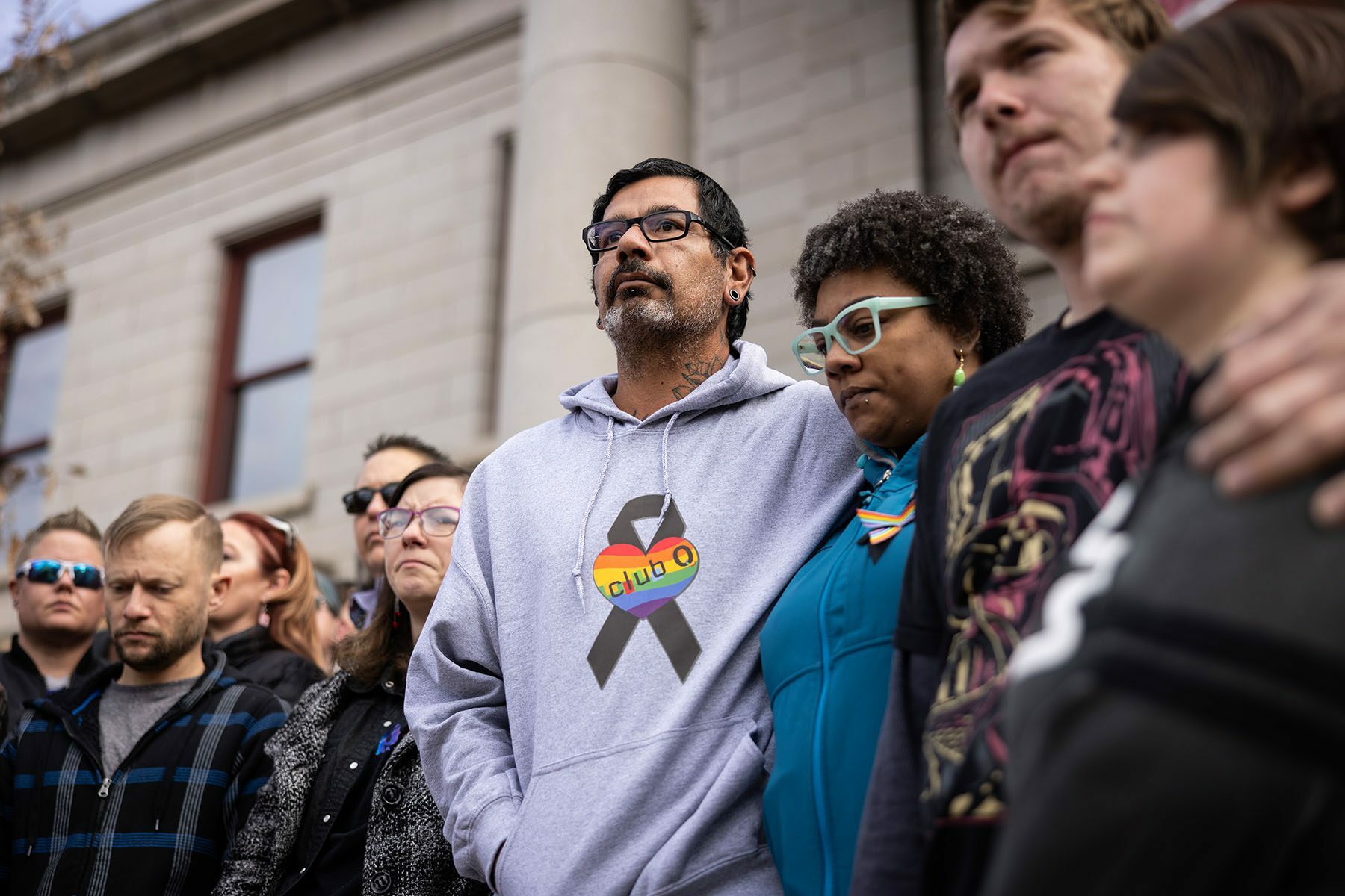 Mourners outside of the Colorado Springs City Hall where a rainbow flag was draped over the building.