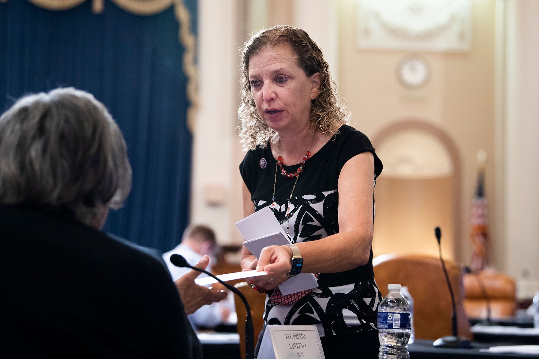 Rep. Debbie Wasserman Schultz hands a fellow representative an envelope on Capitol Hill.