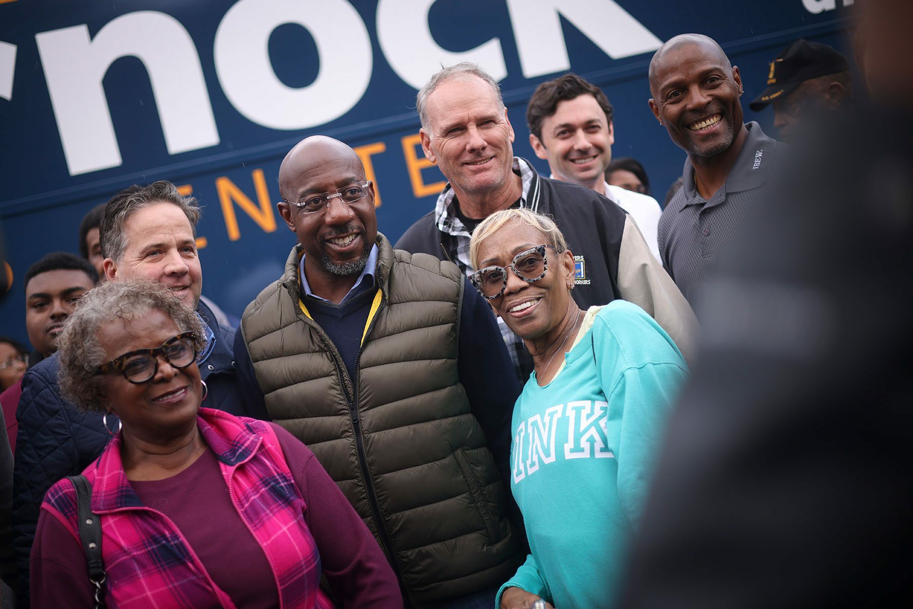 Sen. Raphael Warnock takes photos with supporters after a Get Out the Vote rally.