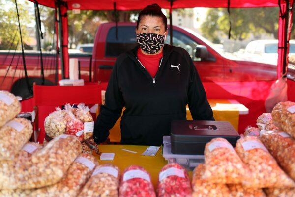 A worker poses for a portrait at a kettle korn stand at a Los Angeles farmers market.