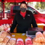 A worker poses for a portrait at a kettle korn stand at a Los Angeles farmers market.