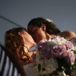 Two women kiss after their wedding ceremony.