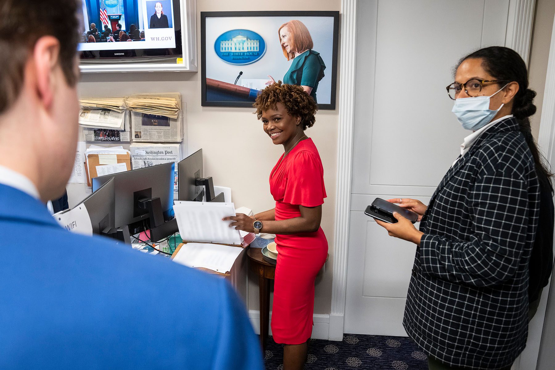 Karine Jean-Pierre smiles as she looks through documents prior to a press briefing at the White House.