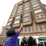 woman in purple shirt protesting outside Boston jail during COVID-19