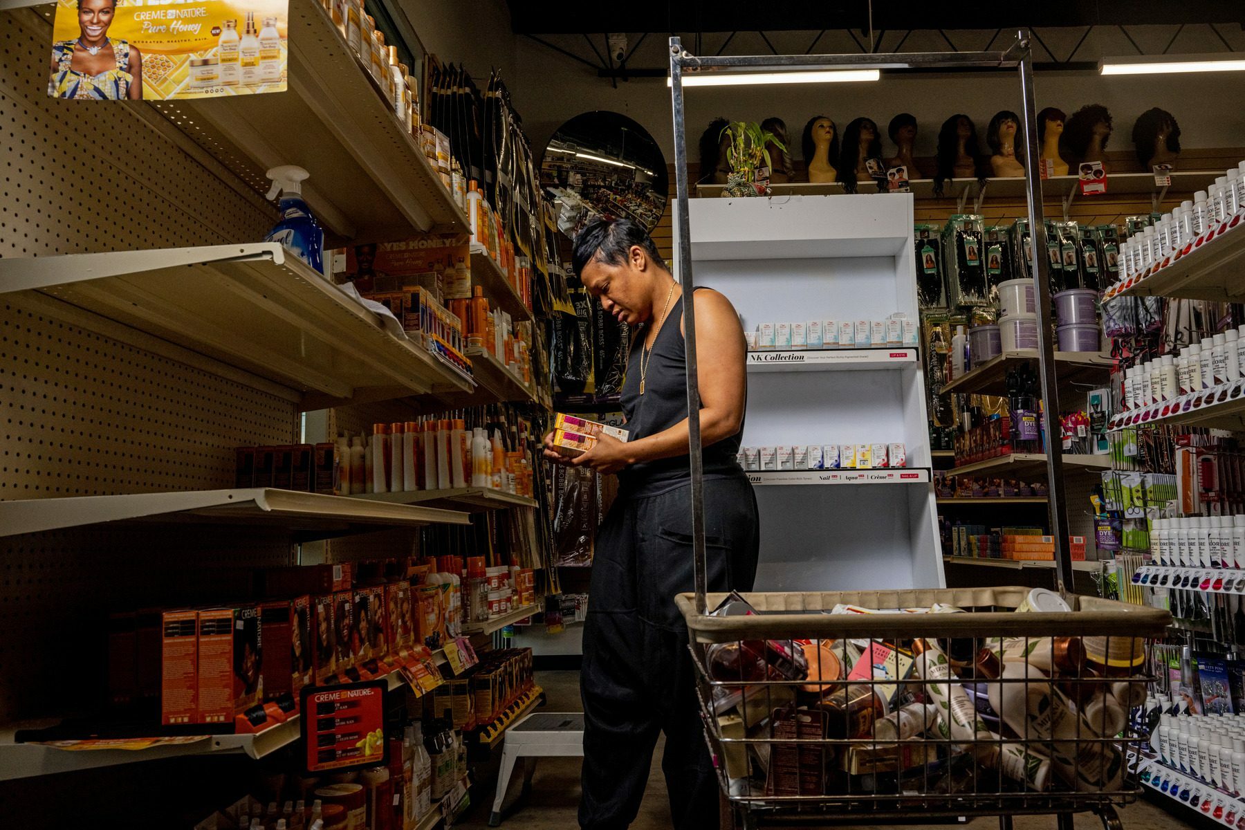 A woman restocks shelves at her business.