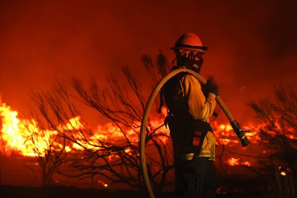 A firefighter monitors the Dixie Fire.