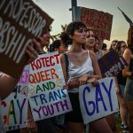 LGBTQ+ rights supporters protest against Florida Governor Ron DeSantis outside a 