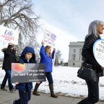 Anti-abortion activists holding signs gather at the Montana State Capitol for the March for Life.