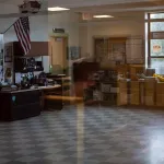 An American flag is seen in an empty classroom.
