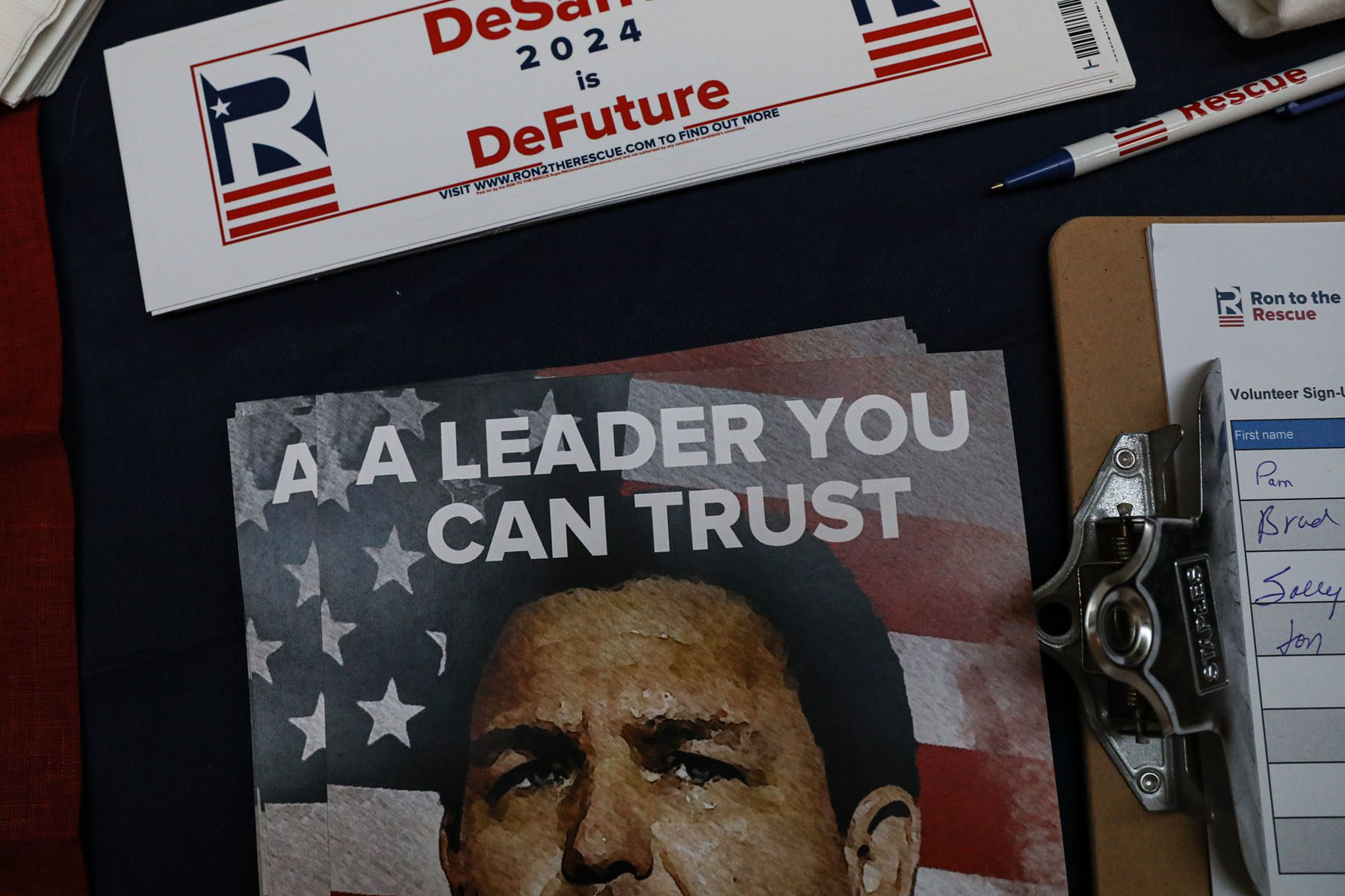Bumper stickers that read "DeSantis 2024 is DeFuture" and a picture of Ron DeSantis inscribed with the words "A leader you can trust" sit on a vendor's table at the New Hampshire Republican State Committee fundraiser.
