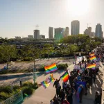Demonstrators wave pride flags as they march across a bridge in protest of Florida's 