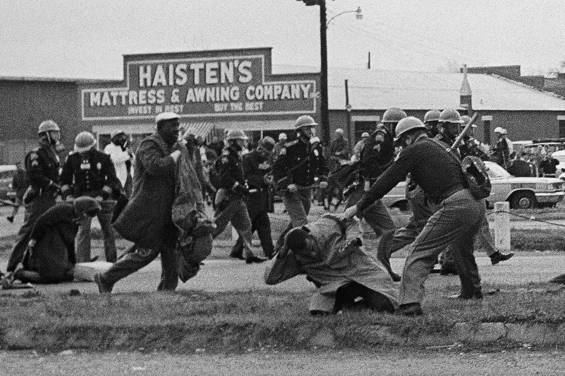 State troopers swing billy clubs to break up a civil rights voting march in Selma, Alabama.