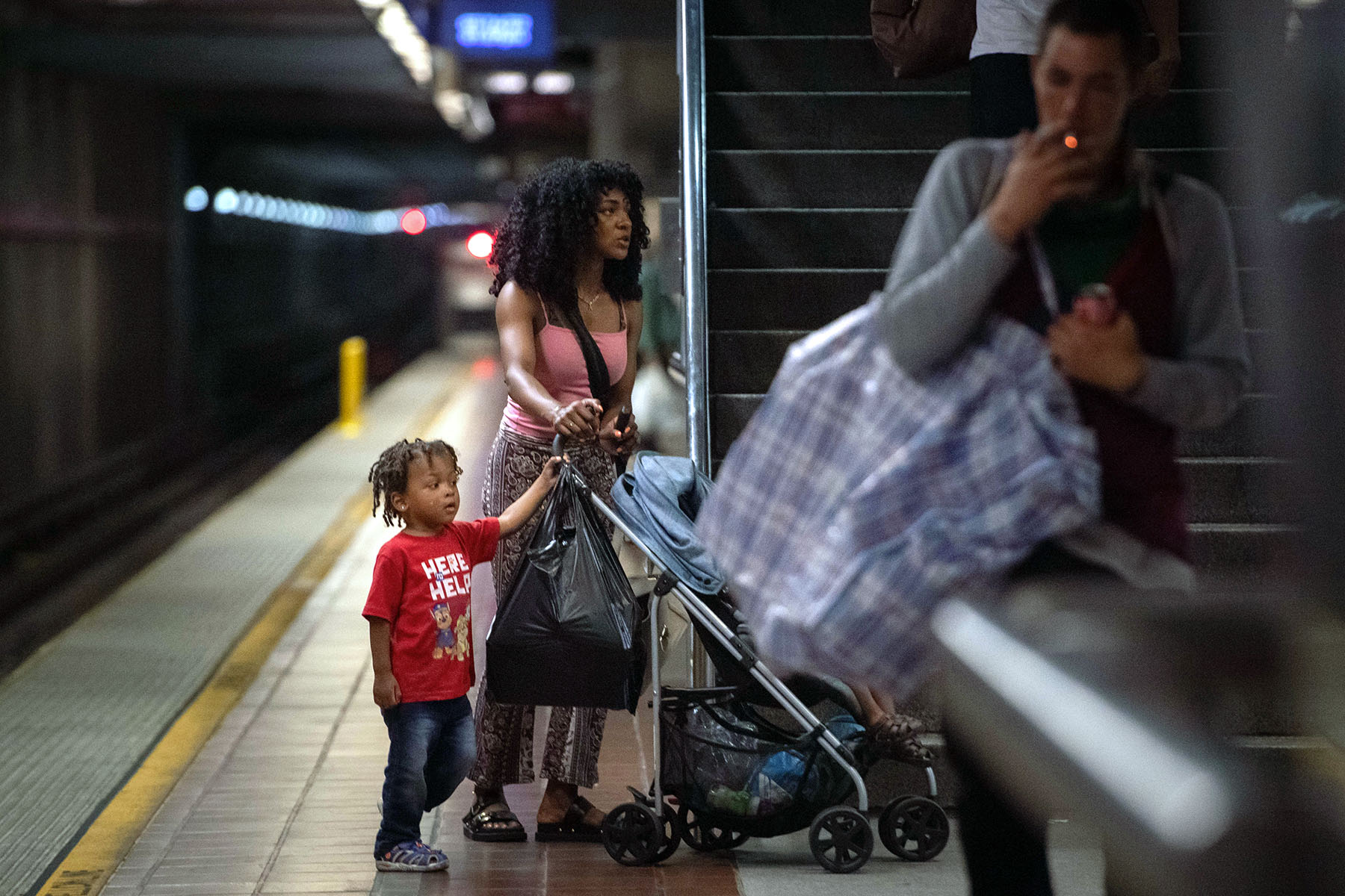 A mother of two young children is seen on a platform of the Los Angeles metro.