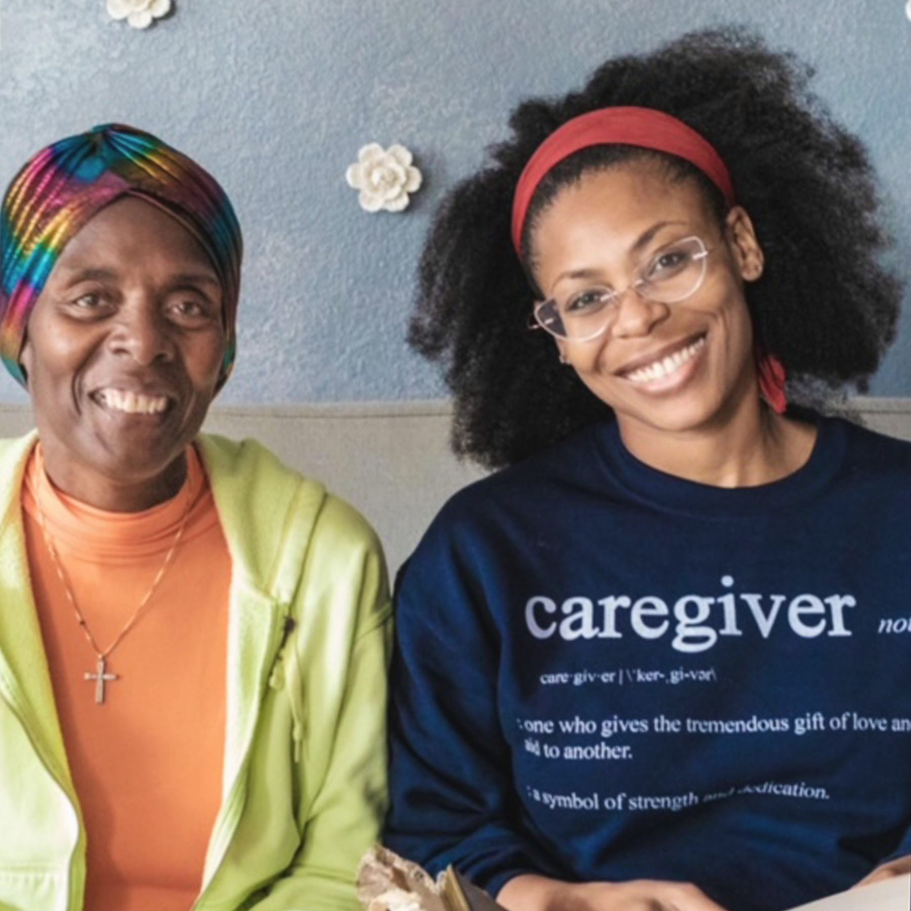 Jacqueline Revere and her mother. They're both smiling and Jacqueline is wearing a sweater with the definition of the word "caregiver" on it.