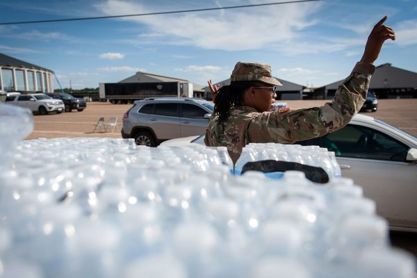 A National Guard directs traffic at a water distribution site at the Mississippi State Fairgrounds.
