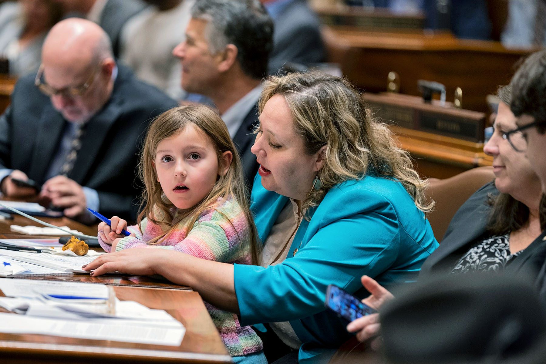 Greenman's niece sits in her lap as she works.