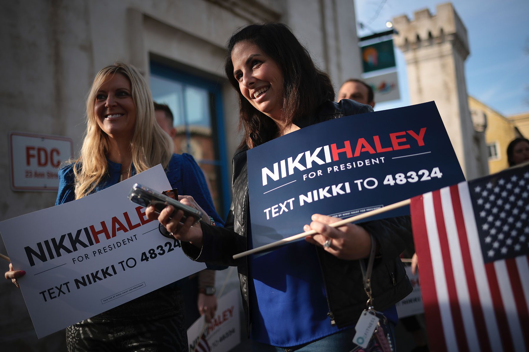 Supporters holding "Nikki Haley For President" signs wait in line before her first campaign event.