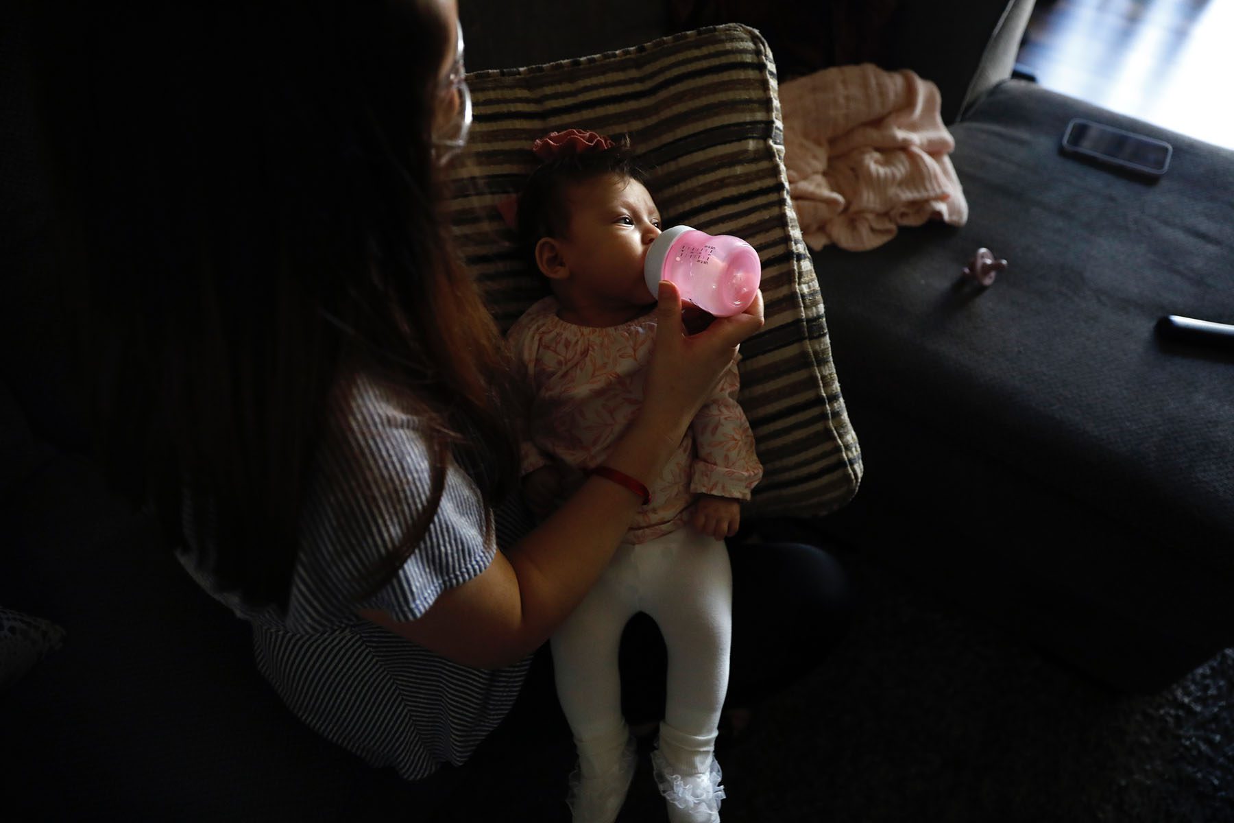 A mother feeds her three month old daughter at home in Los Angeles.