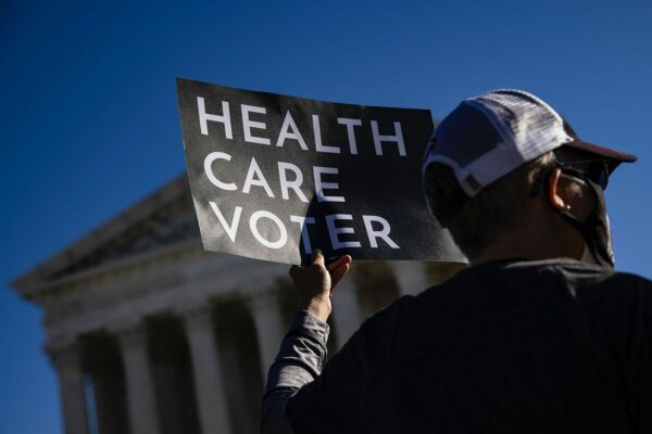 A supporter of the Affordable Care Act holds a sign that reads 