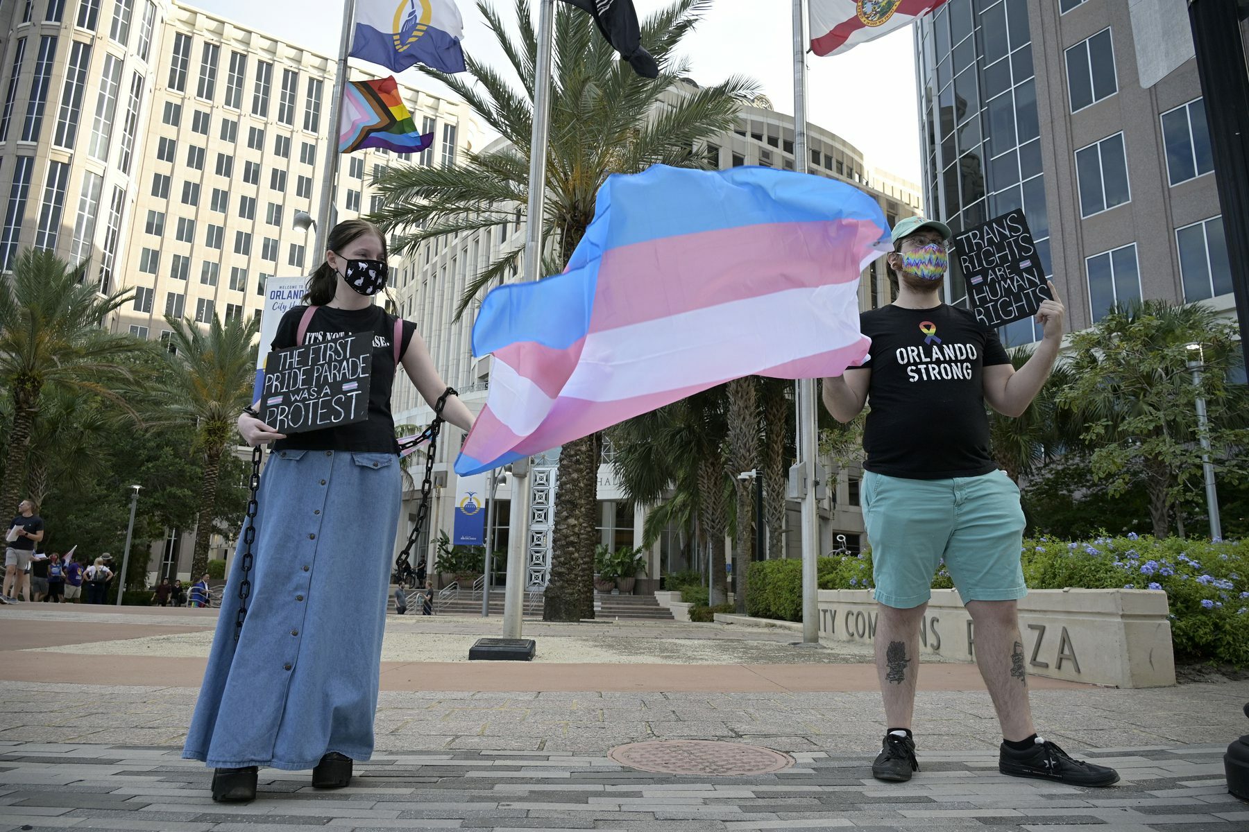 Two activists hold a flag at a rally to protect transgender kids.
