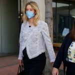 Theranos founder Elizabeth Holmes, pregnant with her first child, leaves the Robert F. Peckham Federal Building with her defense team in downtown San Jose, California in May 2021.