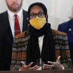 Oklahoma State Rep. Mauree Turner, in glasses and a yellow mask, speaking in Oklahoma City