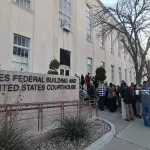 People stand outside of a courthouse.