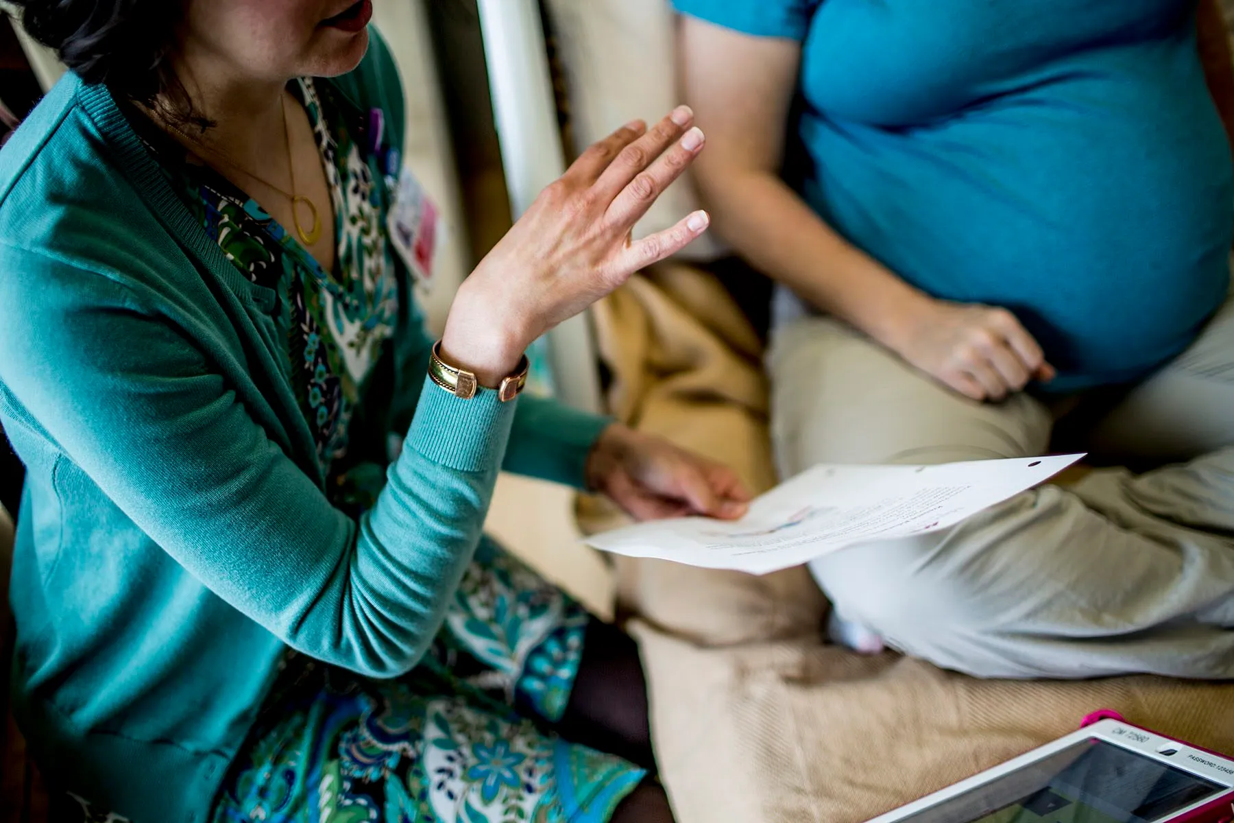 Lactation specialist pictured speaking to a pregnant mother.