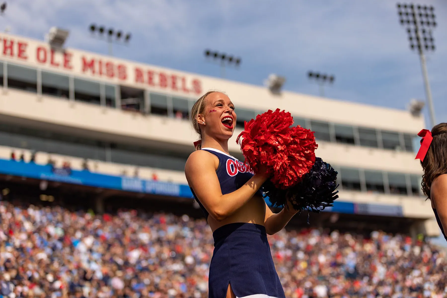 An Ole Miss Rebels cheerleader gets the crowd fired up during a college football game.